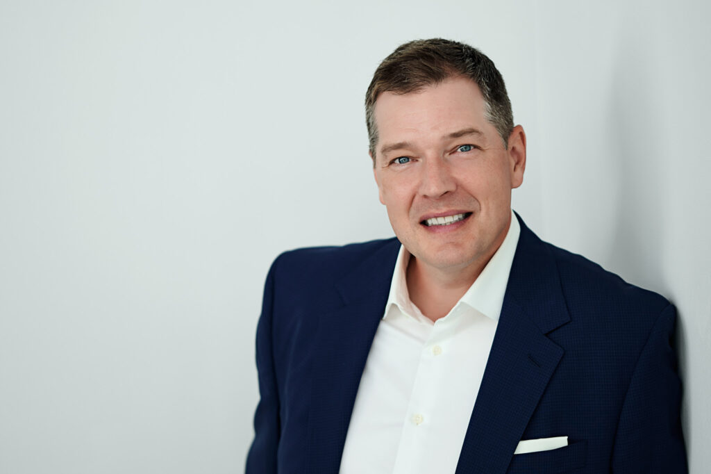 Professor de Beer standing relaxed while wearing a navy suit with a white dress shirt and pocket square.